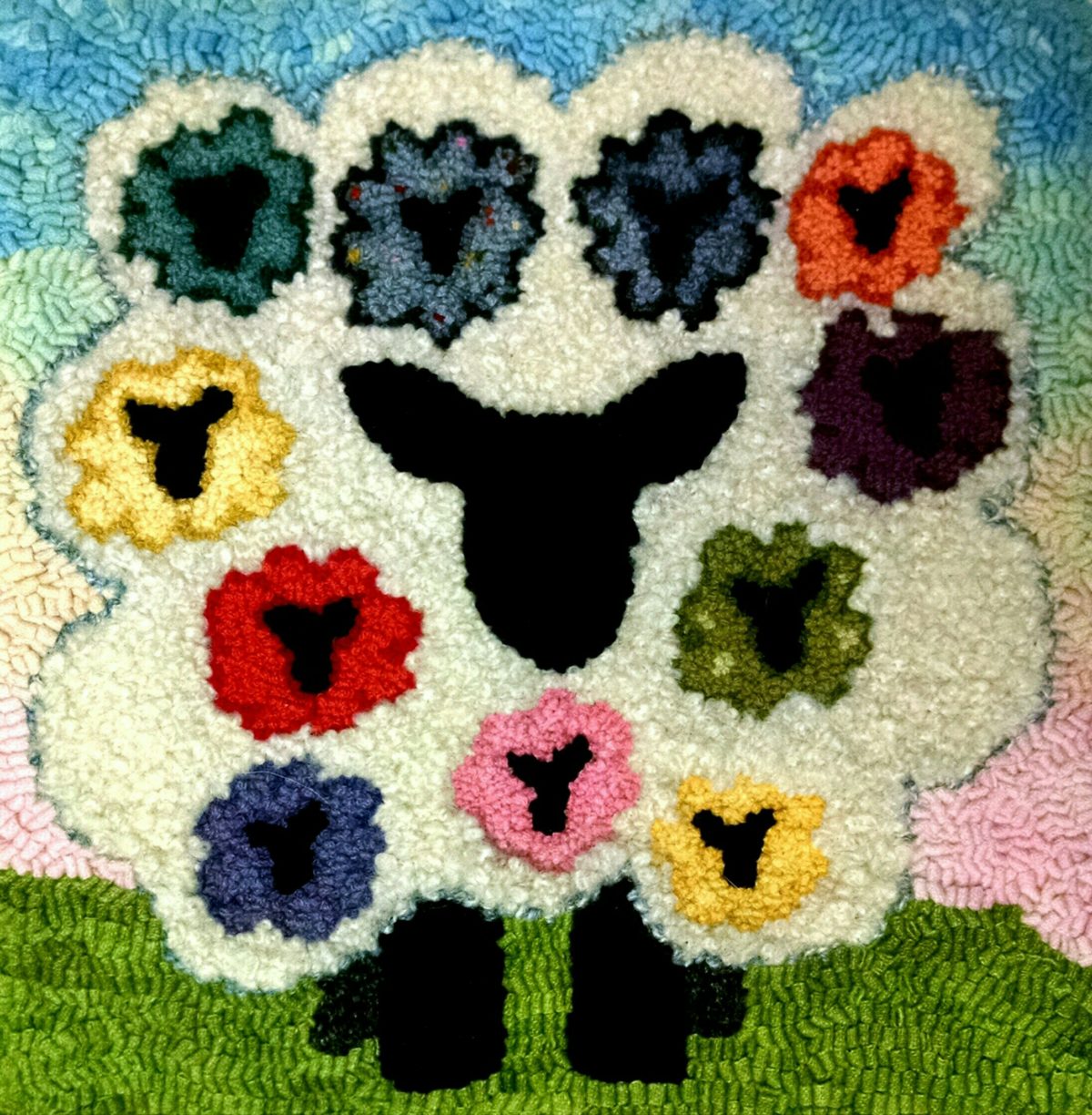 A large sheep with 11 smaller sheep hooked in its curls.