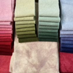 Wool for the red rose kit. Includes light background, dark/light red sashing, 12 value swatch of red, 8 value swatch of yellow/green, 8 value swatch of green, and an 8 value swatch of hydrangea.